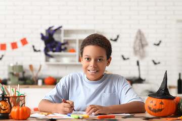 Teenage African-American boy drawing Halloween picture at home
