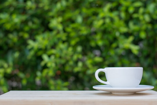 Coffee espresso on wood table nature background in garden,warm tone
