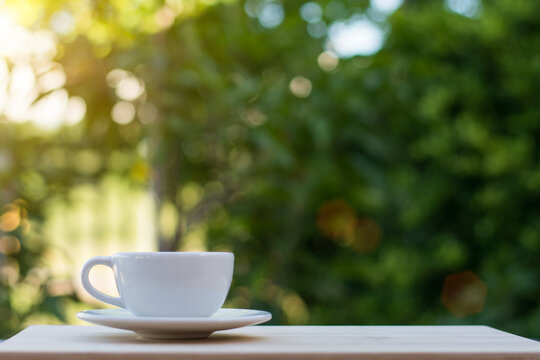 Coffee espresso on wood table nature background in garden,warm tone