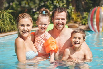 Holiday, portrait or happy family swimming in pool for bonding, vacation or weekend in summer....