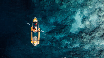 Woman kayaking in ocean on transparent kayak. Drone view with copy space © artifirsov