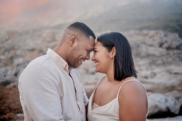Fototapeta premium Bonding, love and couple on beach at sunset on romantic date for travel with vacation or weekend trip. Happy, care and young man and woman with connection by ocean in evening on tropical holiday.