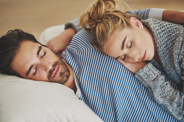 Couple, sleeping and hug together on sofa to relax, rest and cuddle in marriage, relationship or love for partner. Tired, man and woman dreaming with peace in home, house or living room in morning