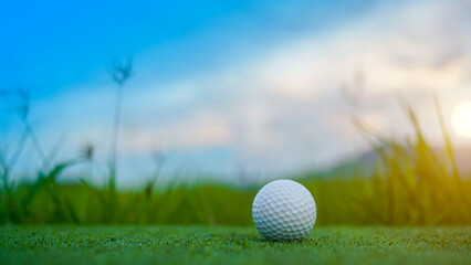Golf ball is on a green lawn in a beautiful golf course with morning sunshine.