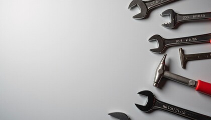 Minimalist Labor Day background with tools like wrenches and hammers scattered on a clean gray surface.
