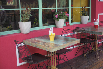 A charming outdoor cafe featuring colorful decor, inviting potted plants, and cozy chairs