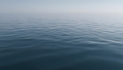 Obraz premium A serene view of calm water with gentle ripples, reflecting a soft blue hue. The surface appears smooth and tranquil, creating a peaceful atmosphere.