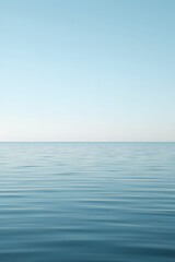 Obraz premium A serene view of calm water with gentle ripples, reflecting a soft blue hue. The surface appears smooth and tranquil, creating a peaceful atmosphere.
