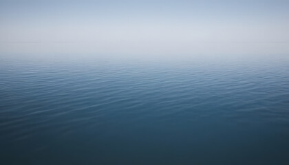 Fototapeta premium A serene view of calm water with gentle ripples, reflecting a soft blue hue. The surface appears smooth and tranquil, creating a peaceful atmosphere.