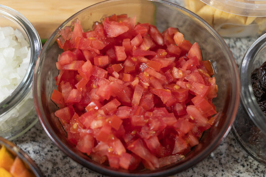 Ingredients to prepare chiles en nogada. Red tomato chopped in squares inside a boul