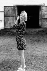 Portrait of a young beautiful girl on a horse farm. Black and white photo.