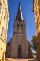 Fototapeta premium Ein Blick durch eine Gasse auf eine Kirche bei schönem Wetter.