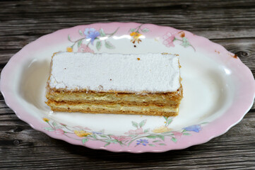 Classic powdered sugar Mille feuille cake gateau made of milk, egg yolks, vanilla extract, caster sugar, cornflour flour, sugar, rolled puff pastry and pastry cream