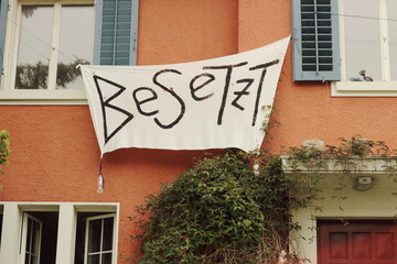 Facade of Squatted Building in Zurich with Besetz Banner