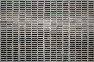 A detailed image of a concrete block wall showcasing a repetitive, geometric pattern.