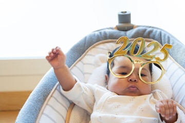 funny portrait of cute dancing baby celebrating with new year 2025 glasses. happy new year 2025 greeting. funny real photo postcard. copy space
