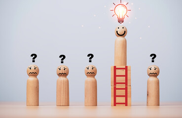 Smile wooden figure standing on the top of ladders with glowing lightbulb among question figure for...