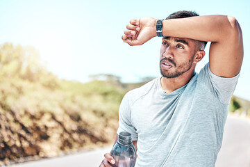 Tired man, fitness and break with water bottle on road for running, exercise or workout in nature. Exhausted male person or runner with sweat, drink or mineral liquid for hydration on mountain street