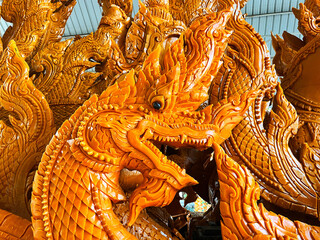 King Of Nagas carving candle, thailand candle culture festival, Golden wax sculpture, Buddhist candle craft festival in Ubonratchathani, dragon candle