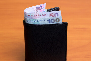 Old Kyrgyz som in the black wallet