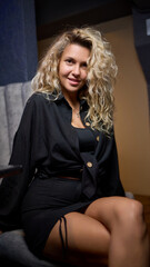 Fototapeta premium An Elegant Woman is Posing in a Stylish and Fashionable Outfit Against a Dark Background