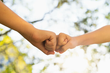 children holding hands, standing on the green grass, the concept of friendship, peace and a group of young people working in a team