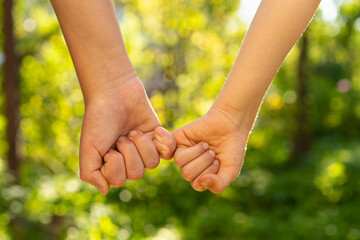 children holding hands, standing on the green grass, the concept of friendship and a group of young people working in a team, a circle of hands