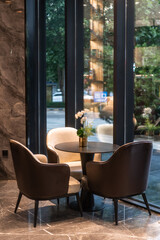 chairs and table near glass wall