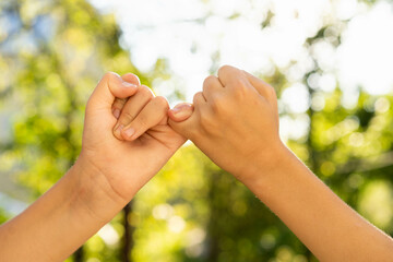 children holding hands, standing on the green grass, the concept of friendship, peace and a group of young people working in a team