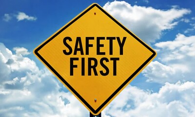 Safety First: Bright Yellow Road Sign with Clear Warning Message Against a Blue Sky with Clouds, Emphasizing Importance of Safety and Precaution
