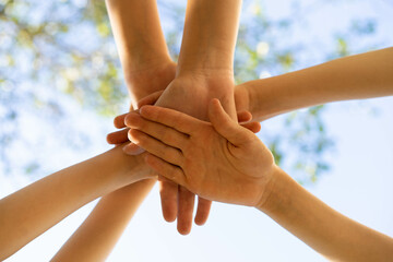 children holding hands, standing on the green grass, the concept of friendship and a group of young people working in a team, a circle of hands