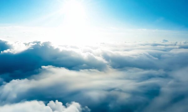 a scenery of sky full of clouds with bright sun on top. the shot moving forward gently and slowly. cloudy day.