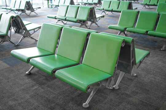Rows of green seats for passengers look empty at the Ahmad Yani International Airport. Semarang, Indonesia. - Powered by Adobe