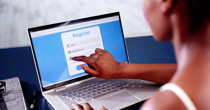 Woman's Hand Filing Online Registration Form On Laptop