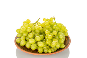Bunch of sweet grapes on a clay plate, macro, isolated on white background.
