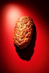 Naklejka premium Delicious Grilled Meat Patty On Red Background