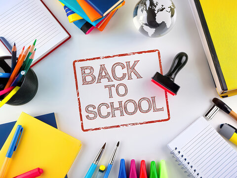 Red Stamp with Back to School on White Desk with School Items