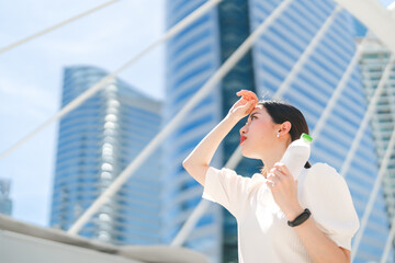Business woman holding drinking water headache and thirsty heat stroke prevention from hot weather