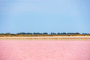 View over the pink salt pans of salt production near the town of Aigues-Mortes in the Camarque region of France