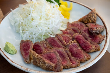 Set of Gyukatsu or beef cutlet served with cabbage. A traditional Japanese food that consists of a deep-fried beef cutlet.