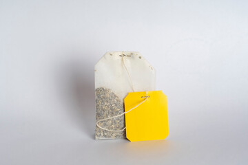 Tea bag with an empty yellow label on a white background. Template with blank tag.