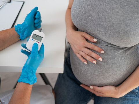 The doctor checks the blood sugar level of a pregnant patient. Gestational diabetes. 