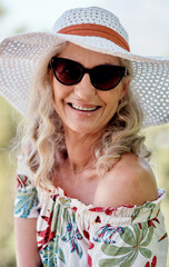 Happy, portrait and sunglasses with senior woman outdoor for holiday, travel or vacation. Face,...