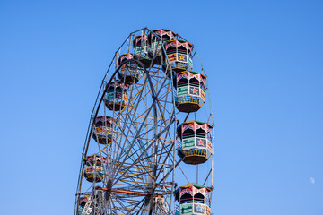 Ferris Wheel or Joint wheel ride running under blue sky on fair ground during the annual dussehra fair.