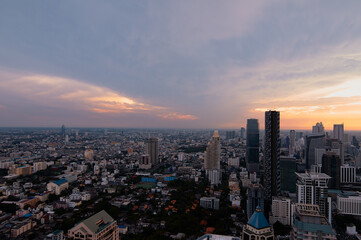 Fototapeta premium Sunset in megalopolis. Beautiful cityscape with top view on skyscrapers. Bangkok, Thailand.