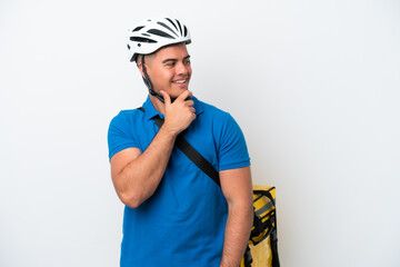 Young caucasian man with thermal backpack isolated on white background looking to the side