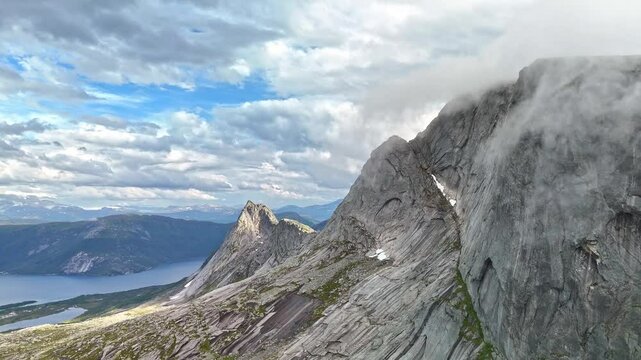 Kulhornet - Clouds and fog rolling over steep mountain  tops formed by glaciers in Efjord in Northern Norway