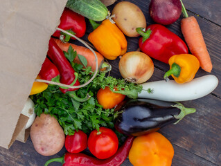 fresh vegetables on a wooden background in a paper bag. Selective focus