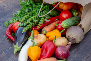 fresh vegetables on a wooden background in a paper bag. Selective focus