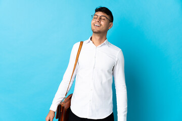 Young business Colombian man isolated on blue background laughing